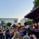Sommerrfest des Verbandes mit Menschen vor einer Bühne im Sonnenuntergang