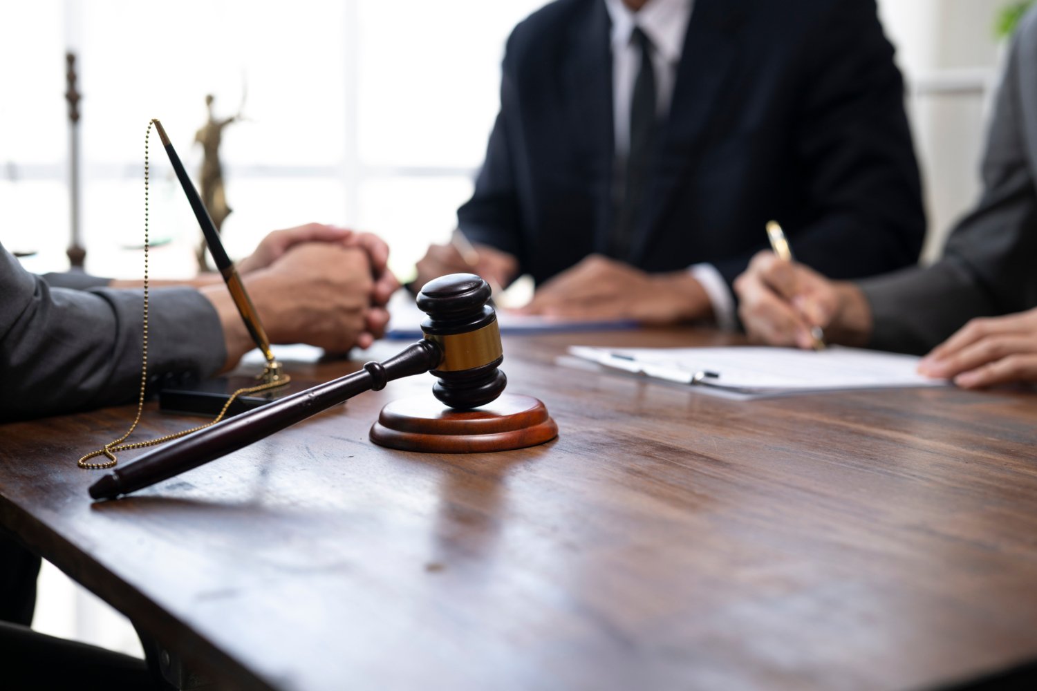 Lawyers discussing and signing legal contract with gavel on table